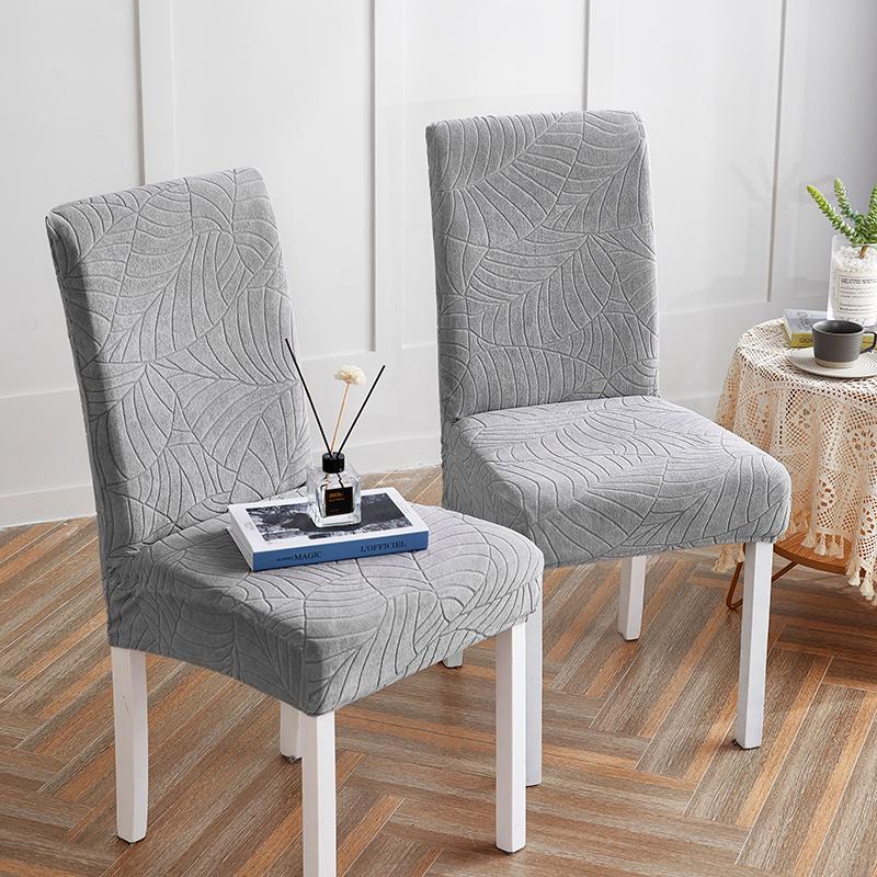 Gray grey textured chair cover on a chair in a room with a small table and decorative items.